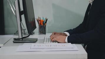 A man in a suit is typing on a computer video