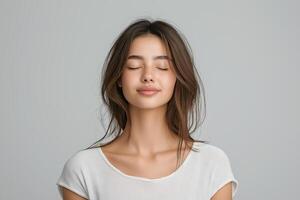 Beautiful young woman with closed eyes and closed eyes on grey background photo