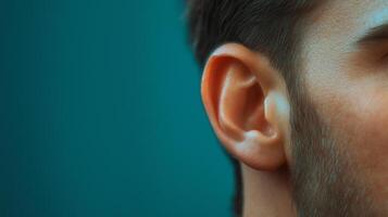 A man's ear with a blue background photo