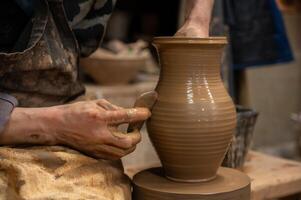 A potter is making a vase on a potter wheel photo