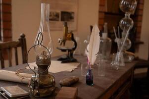 A table with a lamp, a feather, and a book photo
