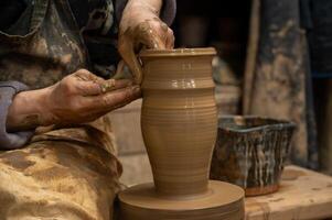 a potter is working on a vase on a potter wheel photo
