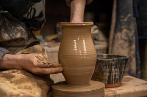 a potter making a vase on a potter wheel photo
