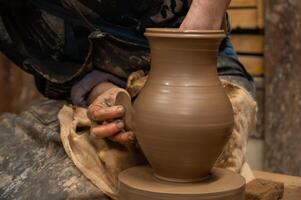 a man is making a pottery vase on a pottery wheel photo