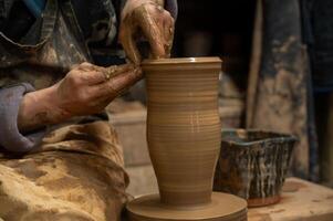 a potter is making a vase on a potter wheel photo