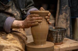 a potter is making a pot on a potter's wheel photo