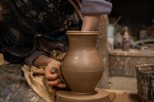 a person is making a pottery vase on a pottery wheel photo