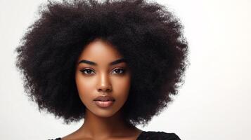 A beautiful woman with a large afro smiles gently towards the camera, looking radiant and healthy against a white background. photo