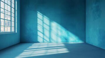 Sunlight streams into an empty blue room through a window, creating light and shadow patterns on the walls and floor, creating serenity. photo