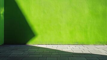 Vibrant green wall with dynamic shadow patterns casting a geometric shape onto the surface and the adjacent stone-tiled ground. photo