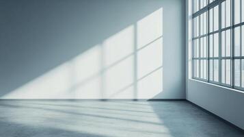 Bright, empty room with sunlight streaming through a large window, casting shadows on the wall and floor, creating geometric patterns. photo