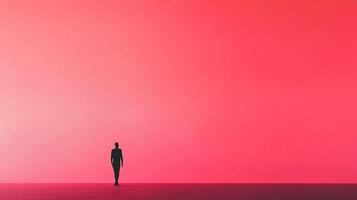 An enigmatic silhouette of a person walking slowly towards a bright red gradient background, evoking feelings of introspection and exploration of the self. photo