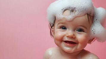 Adorable baby joyfully smiling with a pile of bubbles on their head, set against a soft pink backdrop for pure sweetness. photo