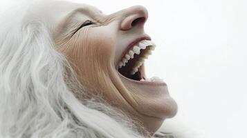 Close-up of a mature person with white hair expressing intense emotion through laughter or shouting with an open mouth. photo