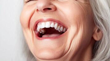 An older woman laughs heartily, showcasing her white teeth and facial wrinkles that are visible as she smiles, showing pure joy. photo