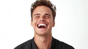 Man with eyes closed and mouth open wide laughs heartily in front of a white backdrop, his dark collared shirt in focus. photo