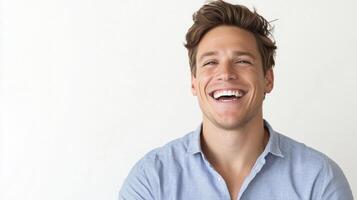 A joyful man with a bright smile showcases happiness and positivity against a neutral backdrop, radiating confidence and approachability. photo