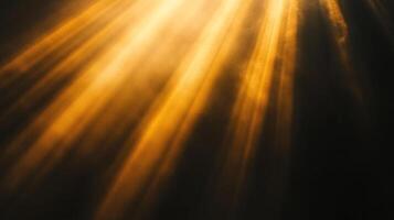 Golden light streams through an opening, casting bright rays onto the dark surface below, creating a contrast between light and shadow. photo