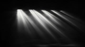 Rays of light slicing through darkness illuminate the empty space, creating a serene yet dramatic monochrome scene. A visual symphony of light and shadow. photo