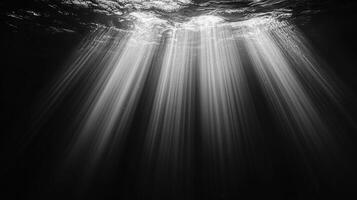 Sunlight filters through the ocean, casting ethereal rays through the water. A serene and mesmerizing display of nature's beauty. photo