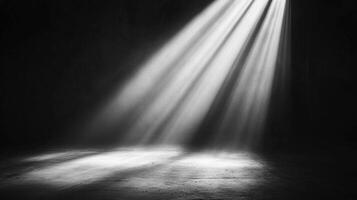 Rays of light pierce through the darkness, illuminating a stage floor creating dramatic contrast and highlighting texture and depth. photo
