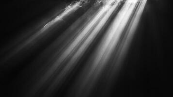 Dramatic monochrome image featuring bright light rays shining through a dark space, creating contrast and a sense of depth. photo