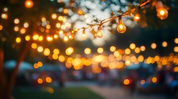Warm lights strung across outdoor gathering, creating a festive and inviting atmosphere with a soft bokeh background. photo
