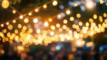 Festive string lights illuminate a blurred, outdoor gathering creating a warm, inviting atmosphere for an evening celebration. photo