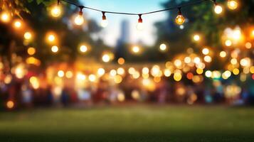 An outdoor evening gathering is illuminated by warm string lights, creating a festive atmosphere in a garden or park setting. photo