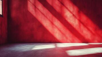 Rays of light shine through a window in an empty room with red walls creating dramatic shadows. The interior has a minimal and simple design. photo
