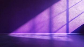 A purple wall is bathed in light, creating an angular pattern as sunshine streams in through a nearby window, filling the room with purple light. photo