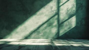 Sunlight casts patterned shadows through the window on a mottled green wall and across the wooden floor in a serene interior space. photo