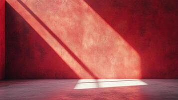 Sunlit red room corner showcasing a striking diagonal ray of light creating a captivating contrast between illumination and shadow. The room is bare. photo