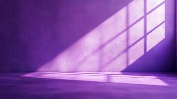 An empty purple room is illuminated by sunlight streaming through a window, casting geometric shadows on the floor and textured wall. photo