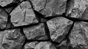 Monochrome image featuring a tightly-packed arrangement of large, rough-textured stones, creating a robust, natural wall-like appearance. photo