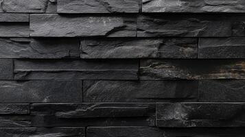 Textured black stone wall exhibiting rough textures, horizontal arrangement, and a dark, sophisticated appearance. Perfect for backgrounds and design. photo