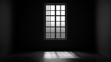 An empty dark room with a single window casting light patterns on the floor, creating contrast and highlighting the room's minimalist space. photo