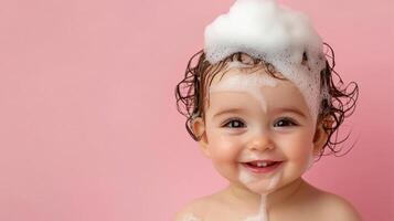 Delightful baby covered in bubbly foam, joyfully smiling against a soft pink background. Capturing innocence and carefree fun. photo