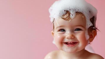 A cheerful infant gleams with happiness during bath time, crowned with fluffy soap bubbles against a soft pink backdrop. photo