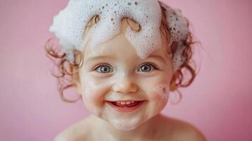 Close-up of a cheerful baby girl, hair covered in bubbly foam, smiling against a soft pink backdrop during bath time, creating a heartwarming scene. photo