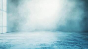 An empty, bluish-grey room with a window casting light on the left wall, filled with haze or fog. A minimal and atmospheric scene. photo