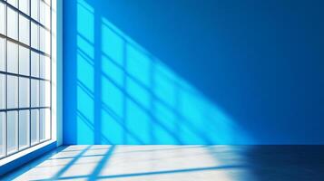 Bright blue room with large window and geometric light patterns casting across the wall and floor. Modern, empty interior space. photo