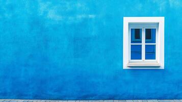 Bright blue wall with a white window evokes serenity and modern simplicity, capturing architectural detail in a vibrant color scheme. photo