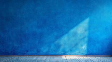 An indigo-colored wall with texture is illuminated by a ray of light, paired with a wood floor with texture and subtle light. photo