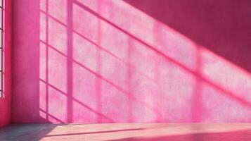 Minimalist room painted in pink with window light casting shadows across the wall and floor, creating a geometric pattern. photo