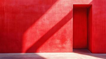 A striking red wall with a deep doorway and a beam of sunlight crossing the surface, creating a bold and minimalist architectural image. photo
