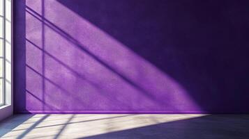 A textured purple wall is bathed in light casting shadows from a window with concrete floor, creating a minimalistic and modern feel. photo