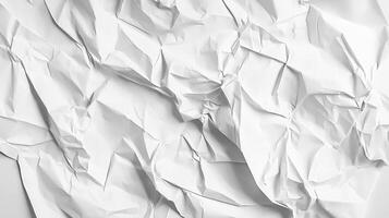 A dramatically lit, crumpled sheet of paper creates abstract patterns of light and shadow, full of texture and visual interest. photo