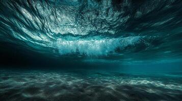 Underwater view of ocean waves and sandy seabed. Waves create abstract patterns of light and shadow. A calming deep sea landscape. photo