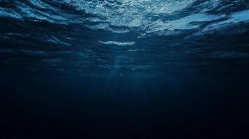 Underwater view capturing the serene dance of light filtering through the ocean surface, creating an ethereal ambiance of deep blue tranquility. photo